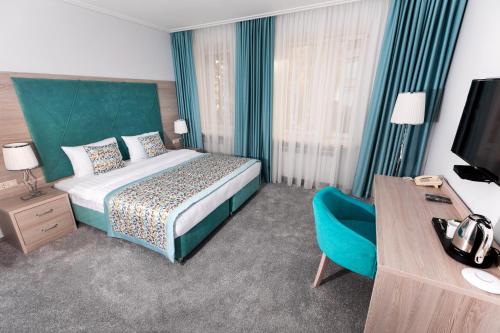 a hotel room with a bed and a blue chair at Soderi's Residence & Spa in Moscow