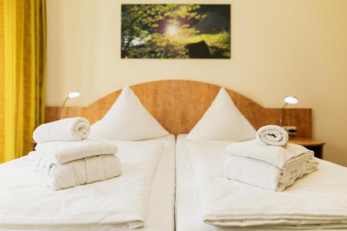 a bedroom with white towels on a bed at Kulturhotel Fürst Pückler Park in Bad Muskau