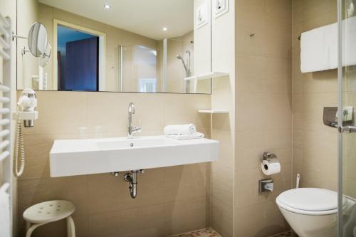 a bathroom with a sink and a toilet at Kulturhotel Fürst Pückler Park in Bad Muskau