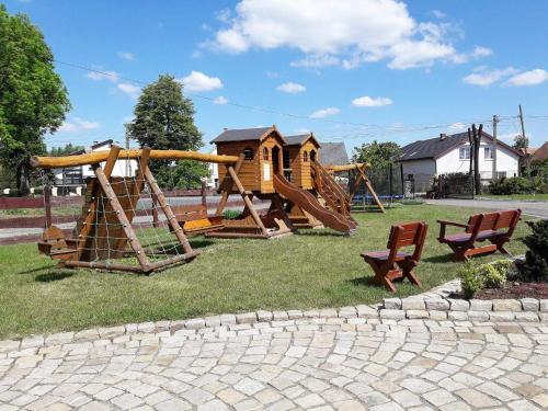 a park with a playground with a slide and chairs at Gościnna Zagroda Gościejowice Noclegi Apartamenty Agroturystyka Niemodlin in Niemodlin