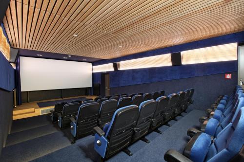 a lecture room with chairs and a blank screen at JUFA Hotel Murau in Murau