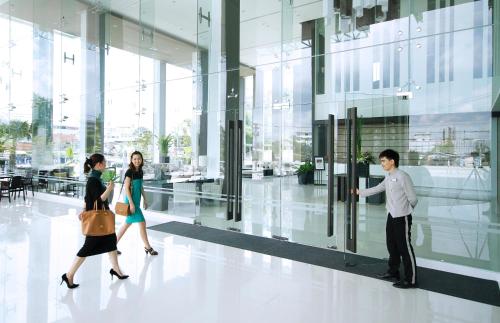 a group of people walking in a building at Classic Kameo Hotel & Serviced Apartment, Rayong in Rayong