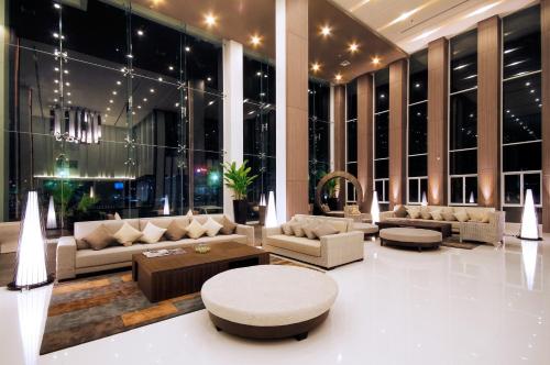 a living room with couches and tables in a building at Classic Kameo Hotel & Serviced Apartment, Rayong in Rayong