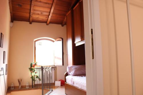 een slaapkamer met een bed, een spiegel en een raam bij Casa vacanze Elena in Rometta