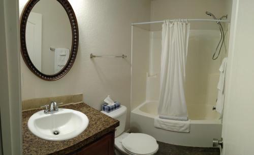 a bathroom with a sink and a toilet and a mirror at Campbell's Accommodations in Gull Lake