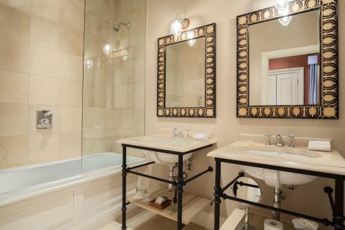 a bathroom with two sinks and a mirror and a tub at Roseate House London in London