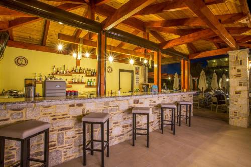 a bar with a row of stools in a restaurant at Georgia Plus - All Inclusive in Afantou