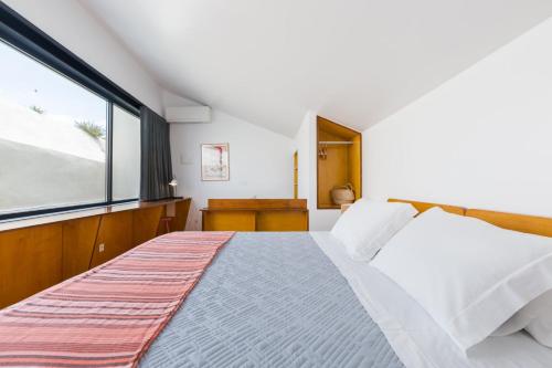 een slaapkamer met een bed en een groot raam bij Patio São Vicente in Lissabon