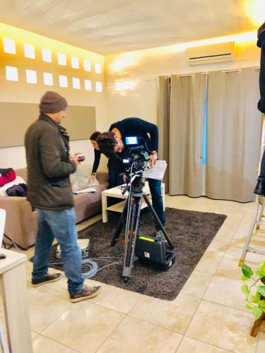 two people standing in a room with a camera at La Porta Nel Giardino in Asti