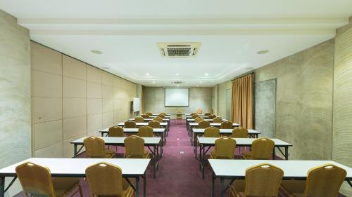an empty room with tables and chairs and a screen at S Park Design Hotel in Vientiane