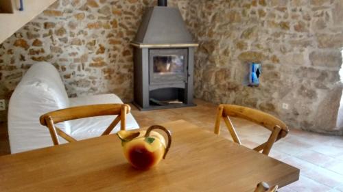 a table with an apple on it with a fireplace at Gîte H.PETIT in Vagnas