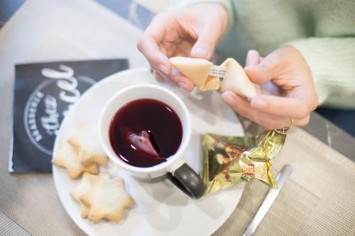 Een persoon die een gelukskoekje naast een kop koffie houdt. bij Casa degli Orefici in Campobasso