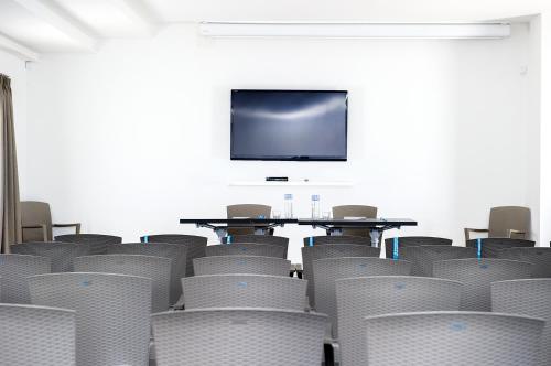 a conference room with chairs and a table and a tv at Camping Village Baia Azzurra in Castiglione della Pescaia