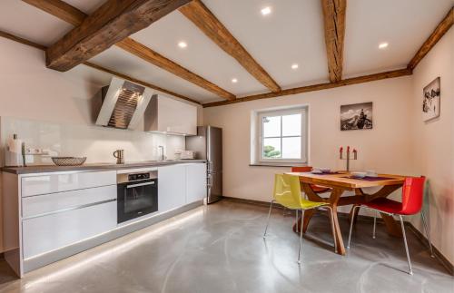 una cucina con tavolo e sedie in legno e tavolo e una cucina con di Ferienappartements Tor zum Allgäu a Vogt