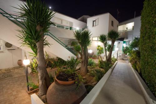 a courtyard with palm trees and a building at night at Eligonia Hotel Apartments in Ayia Napa