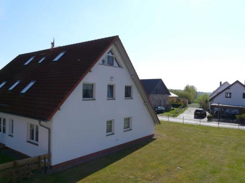 a white house with a brown roof at Ferienwohnung Ankerplatz_VOLB in Ostseebad Karlshagen