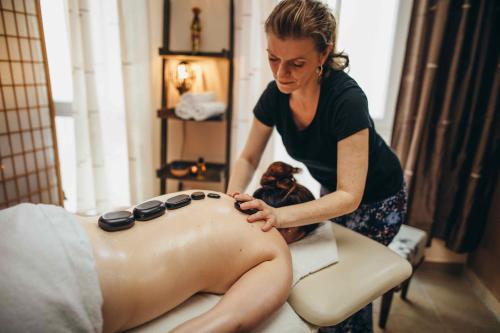 a woman getting a back massage in a salon at Kulturhotel Fürst Pückler Park in Bad Muskau