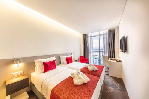 a hotel room with two beds and a window at Meliá Maputo Sky in Maputo