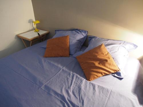 a bed with blue sheets and two pillows at Home Opéra in Marseille