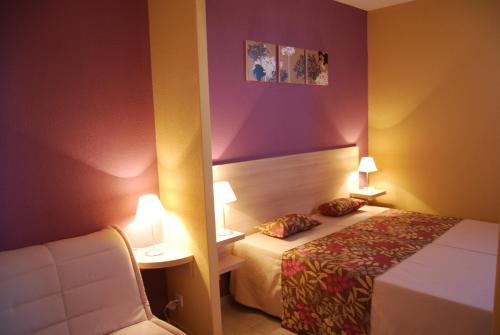 une chambre d'hôtel avec un lit et une chaise dans l'établissement Lagrange Grand Bleu Vacances – Résidence Le Mas de Torreilles, à Torreilles