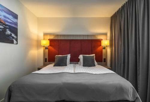 a bedroom with a large white bed with two pillows at Hotel Oxelösund in Oxelösund