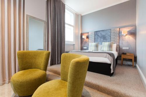 アバディーンにあるアバディーン ダグラス ホテルのベッド1台と椅子2脚が備わるホテルルームです。