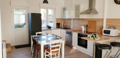 une cuisine avec une table et quelques chaises dans l'établissement Gîte du Port de Saint Valery, à Saint-Valery-sur-Somme