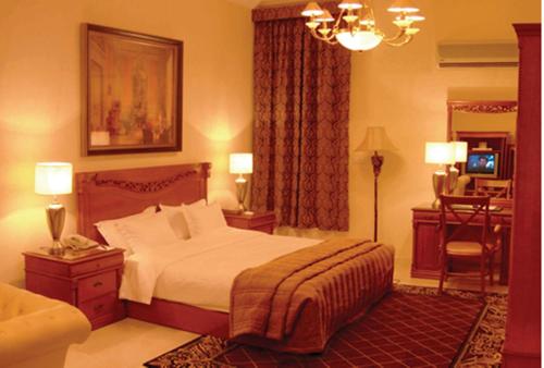 a bedroom with a bed and a desk in it at Issham Hotel in Jeddah