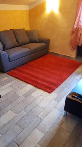 a living room with a couch and a red rug at Casa di Tia in Aosta