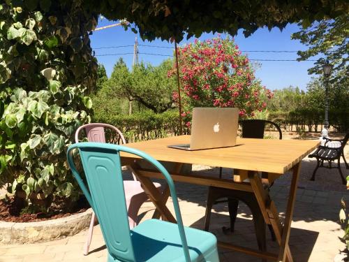 a wooden table with a laptop computer on it at Casa de Los Lirios in Muro de Alcoy
