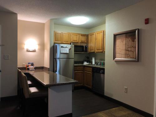 a kitchen with a refrigerator and a counter top at Staybridge Suites Grand Rapids-Kentwood, an IHG Hotel in Grand Rapids