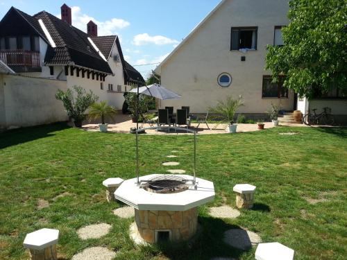 a fire pit in the yard of a house at Alex's Apartman & Panzió in Hajdúszoboszló