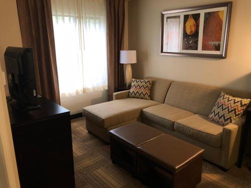 sala de estar con sofá y TV en Staybridge Suites Grand Rapids-Kentwood, an IHG Hotel, en Grand Rapids