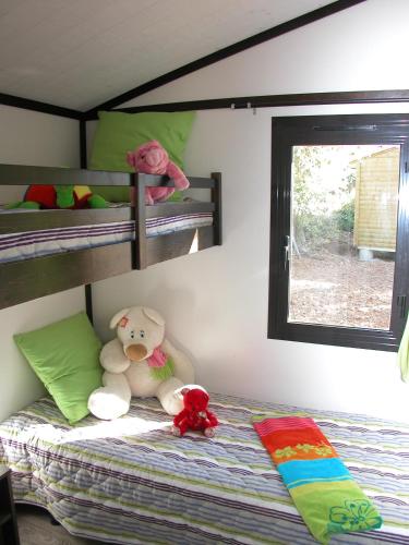 - une chambre avec 2 lits superposés et un ours en peluche dans l'établissement Résidence Lagrange Vacances - Les Cottages Varois, à Solliès-Toucas