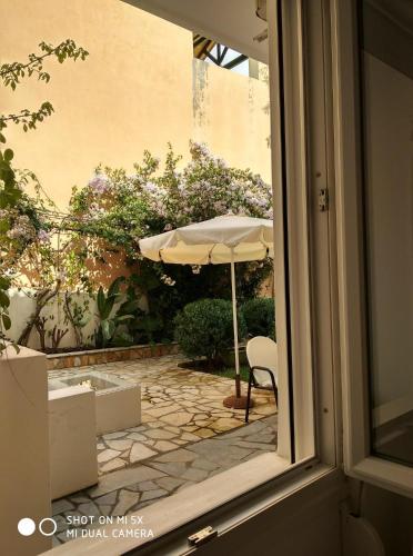an outside window with an umbrella and a patio at Waterside Apartments in Ayia Evfimia