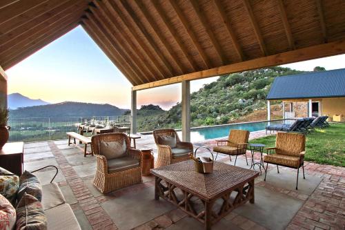 a patio with chairs and a table and a pool at 7 Koppies in Franschhoek