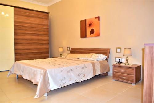 a bedroom with a large bed and a wooden door at Ullswater No. 9 in Marsaskala