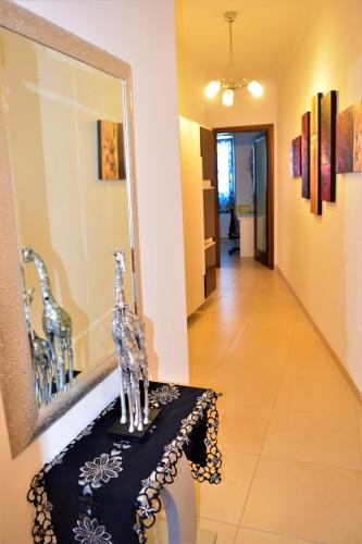 a room with a mirror and a table with a giraffe statue at Ullswater No. 9 in Marsaskala