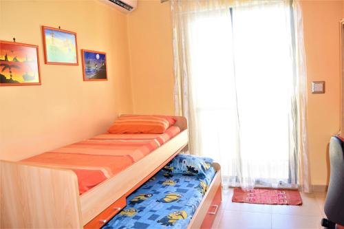 a small bedroom with a bed and a window at Ullswater No. 9 in Marsaskala