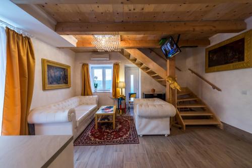 a living room with a couch and a tv and stairs at Villa Art House with Pool in Vižinada