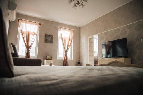 1 dormitorio con 1 cama y TV de pantalla plana en Апартамент Барок en Lovech