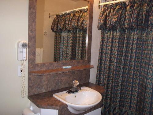 uma casa de banho com um lavatório e um espelho em Motel Normandie em Louiseville