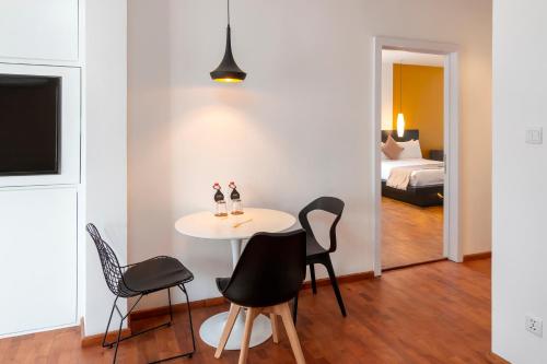 a dining room with a table and chairs and a bedroom at TAO Riverside Residence in Phnom Penh