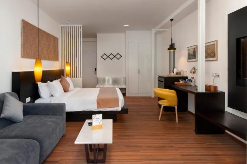 a hotel room with a bed and a couch at TAO Riverside Residence in Phnom Penh
