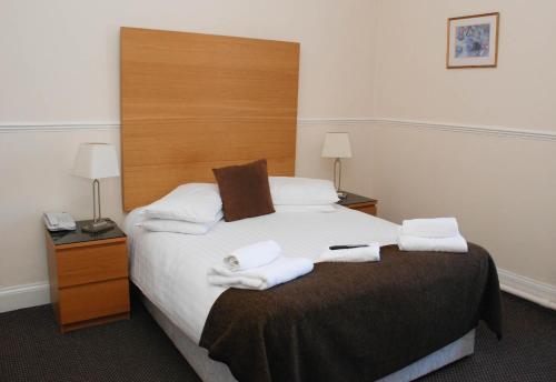 a bedroom with a large bed with towels on it at Birnam Hotel in Dunkeld
