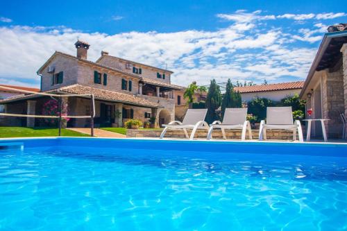 a villa with a swimming pool in front of a house at Villa Luna in Selina in Selina