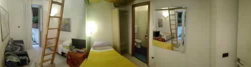 a living room with a yellow bed and a mirror at Buonanotte & Buongiorno Guesthouse in Naples