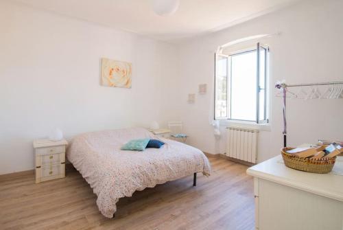 a white bedroom with a bed and a window at Amazing Sea view, free parking, near to the centre in Trieste