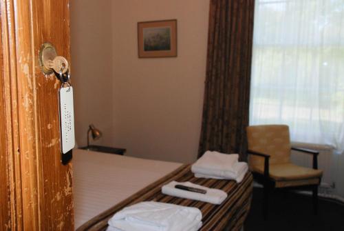 a hotel room with a bed and a chair at Birnam Hotel in Dunkeld