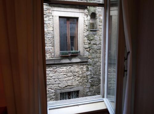 a window view of a stone building with a fireplace at casa medioevo in Viterbo